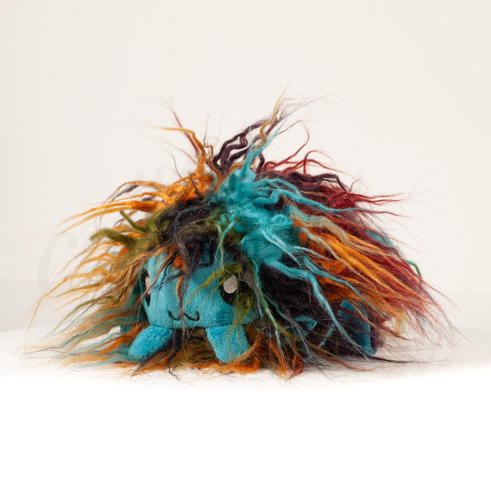Front view of a cuttlepod plush toy, captured at a slight angle to highlight its charming features: large, cartoonish eyes, ruffled fins, and a cuddly, furry texture.