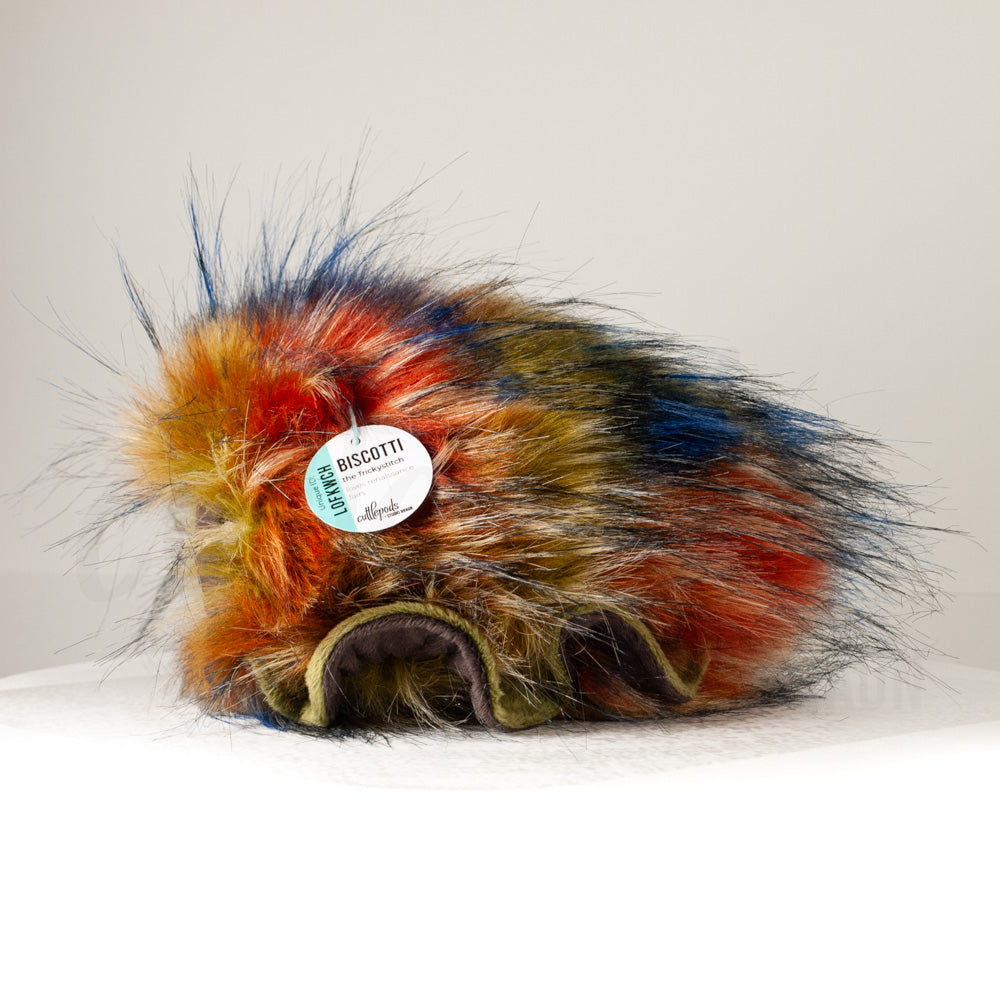 Side profile view of a cuttlepod plush toy, showcasing two-tone ruffled fins, and a cuddly, furry body.