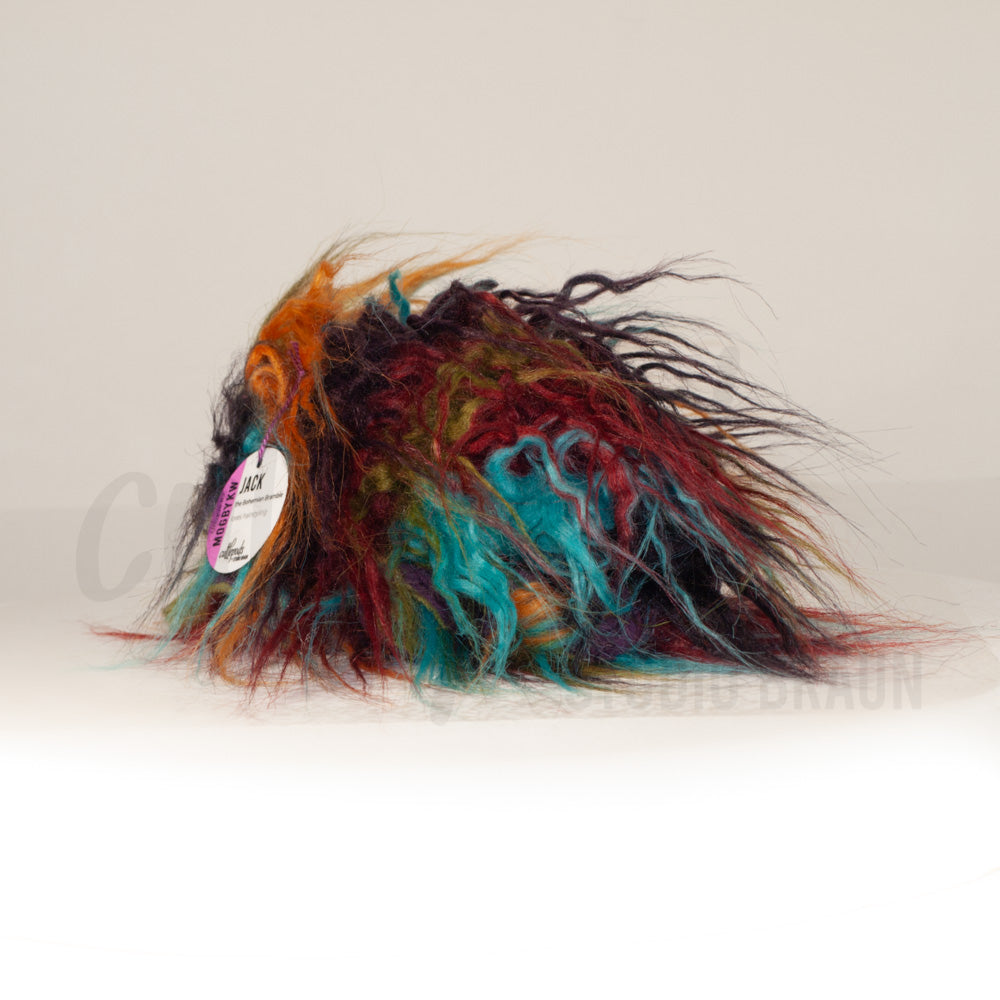 Slightly angled back view of a cuttlepod plush toy, highlighting two-tone ruffled fins, and a cuddly, furry body that comes to a soft point at the rear.