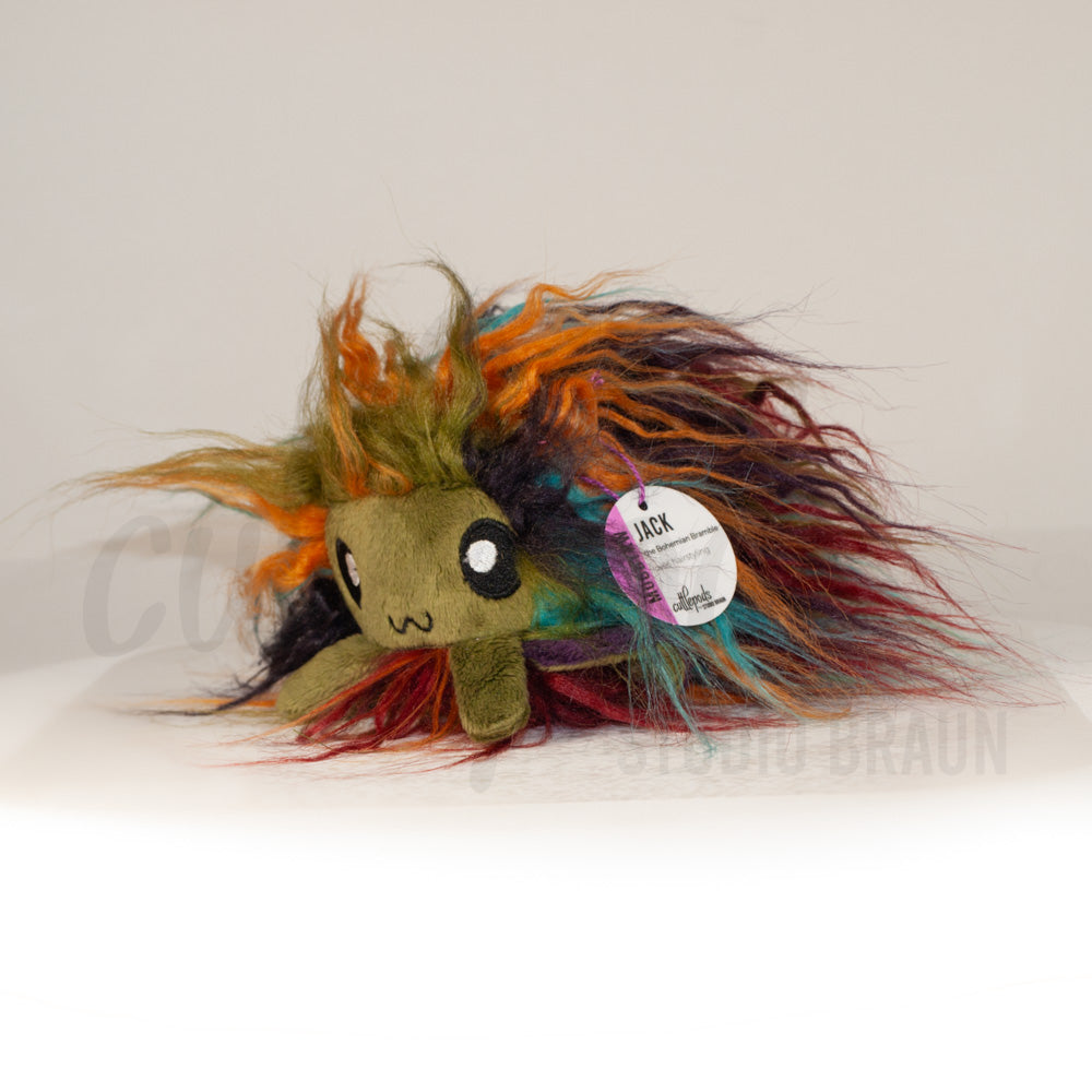 Front view of a cuttlepod plush toy, captured at a slight angle to highlight its charming features: large, cartoonish eyes, ruffled fins, and a cuddly, furry texture.