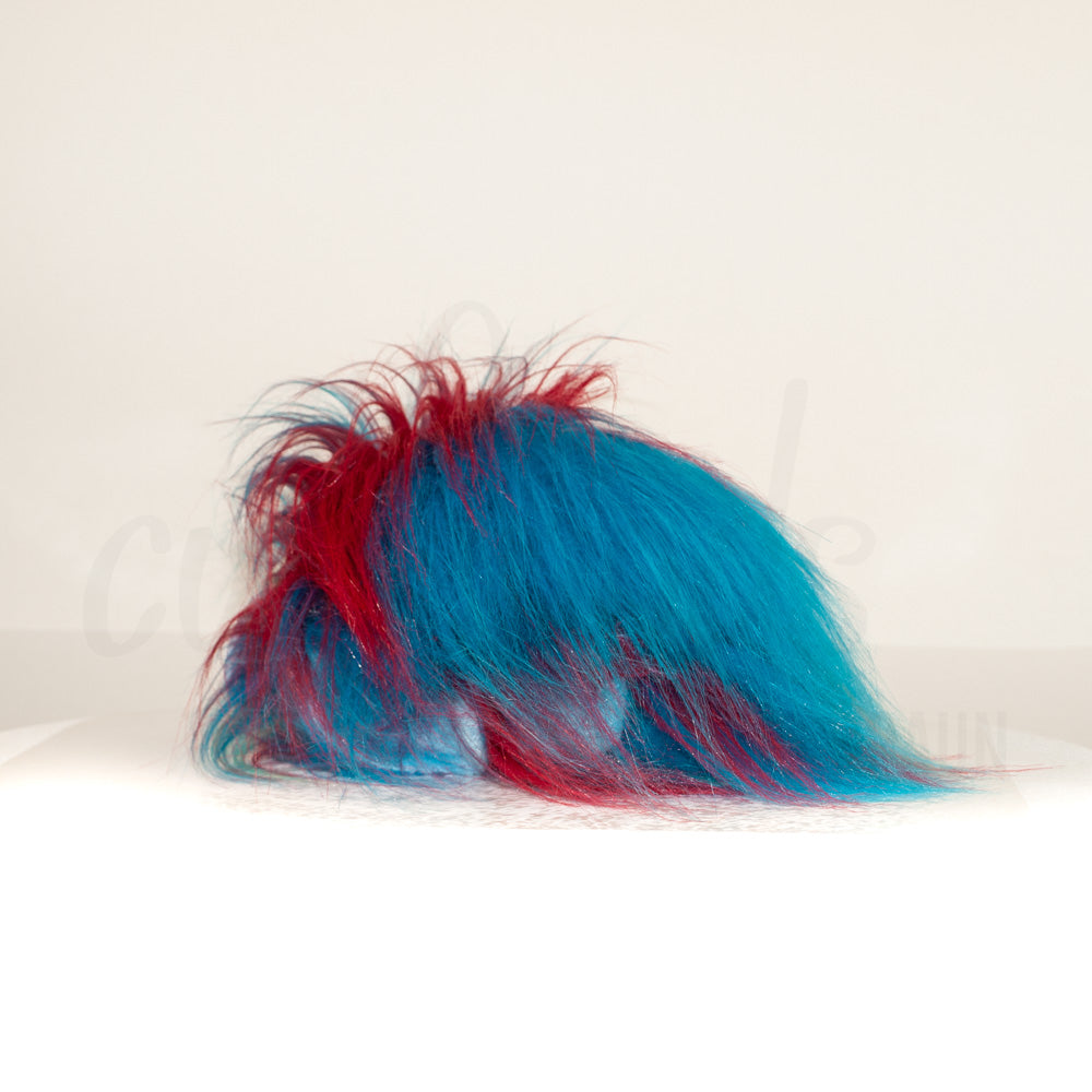 Slightly angled back view of a cuttlepod plush toy, highlighting two-tone ruffled fins, and a cuddly, furry body that comes to a soft point at the rear.