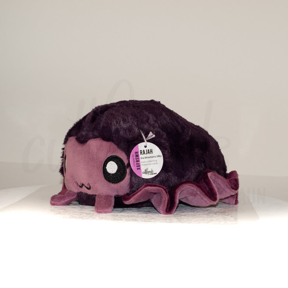 Front view of a cuttlepod plush toy, captured at a slight angle to highlight its charming features: large, cartoonish eyes, ruffled fins, and a cuddly, furry texture.