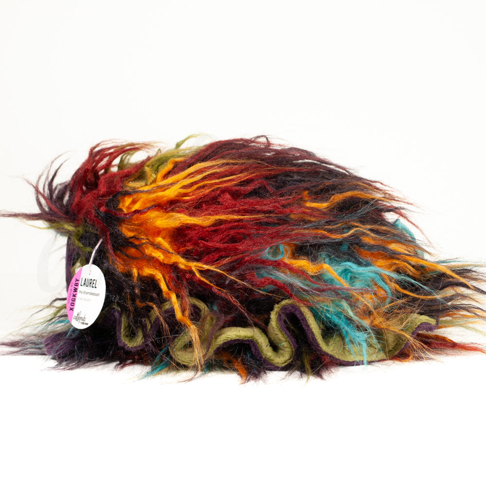 Side profile view of a cuttlepod plush toy, showcasing two-tone ruffled fins, and a cuddly, furry body.