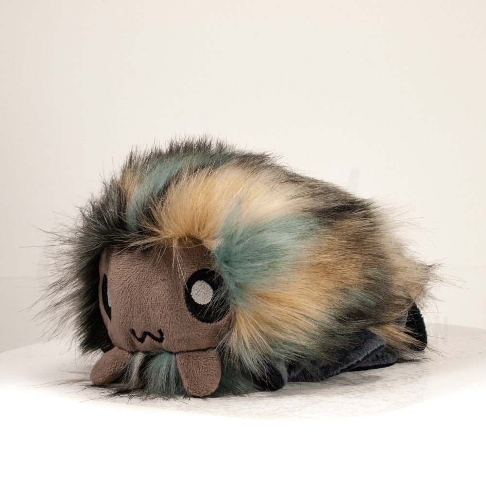 Front view of a cuttlepod plush toy, captured at a slight angle to highlight its charming features: large, cartoonish eyes, ruffled fins, and a cuddly, furry texture.