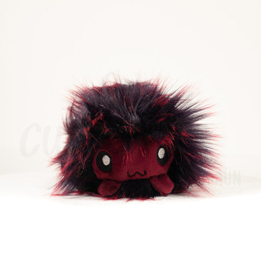 Front view of a cuttlepod plush toy, showcasing its unique form with large, cartoonish eyes, ruffled fins, and a cuddly, furry texture.