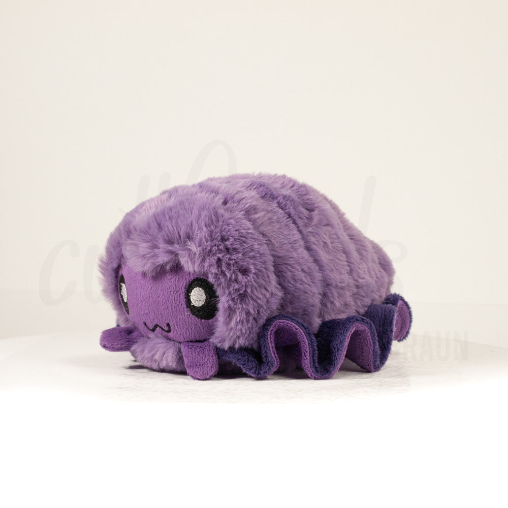 Front view of a cuttlepod plush toy, captured at a slight angle to highlight its charming features: large, cartoonish eyes, ruffled fins, and a cuddly, furry texture.