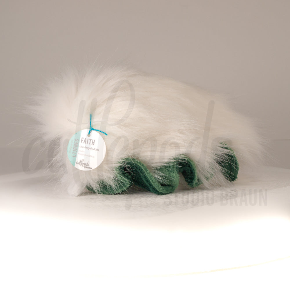 Side profile view of a cuttlepod plush toy, showcasing two-tone ruffled fins, and a cuddly, furry body.