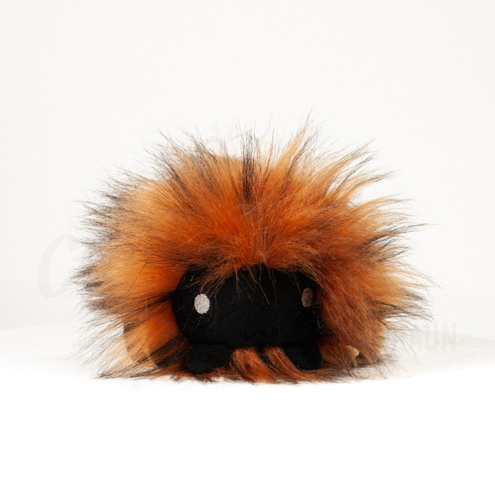 Front view of a cuttlepod plush toy, showcasing its unique form with large, cartoonish eyes, ruffled fins, and a cuddly, furry texture.