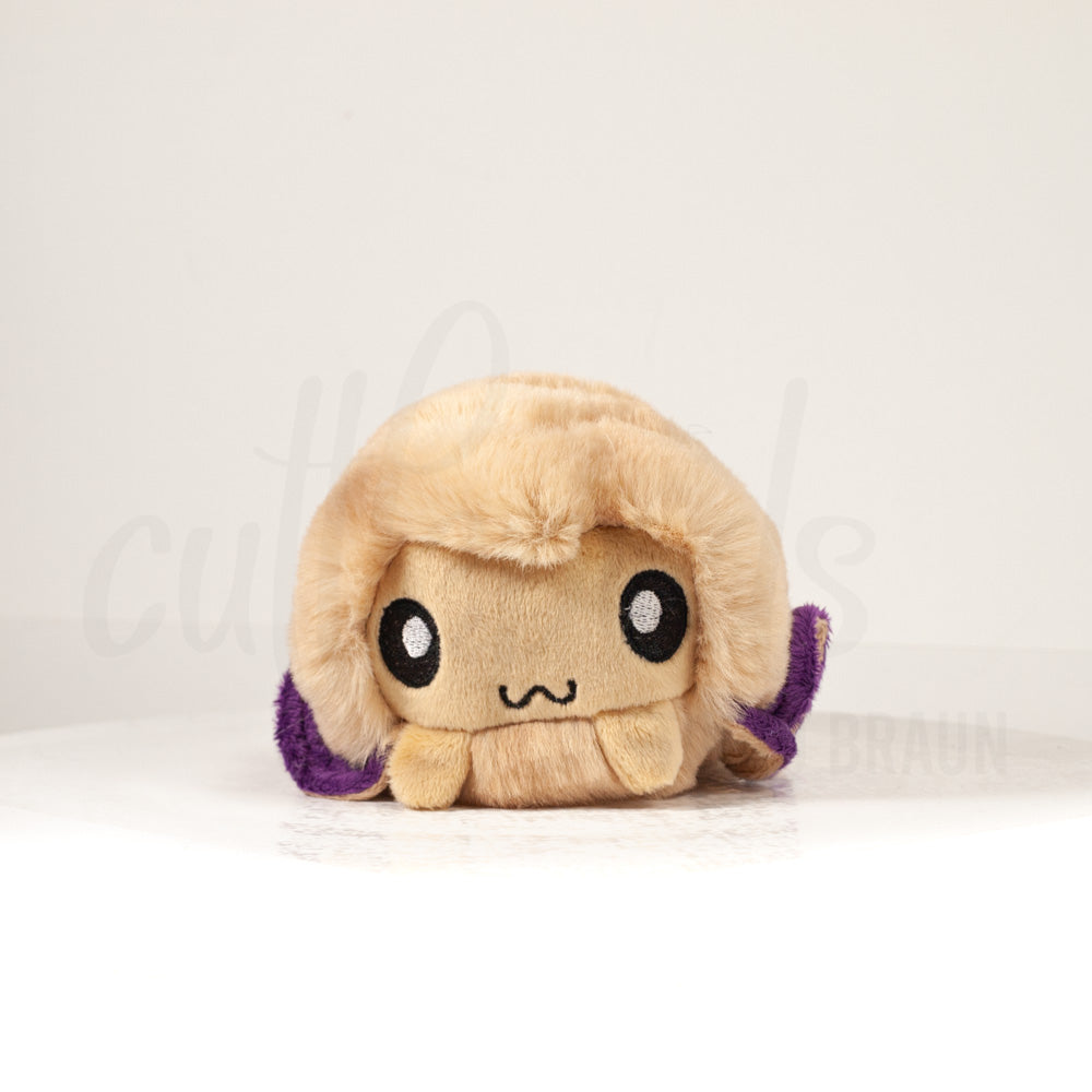 Front view of a cuttlepod plush toy, showcasing its unique form with large, cartoonish eyes, ruffled fins, and a cuddly, furry texture.