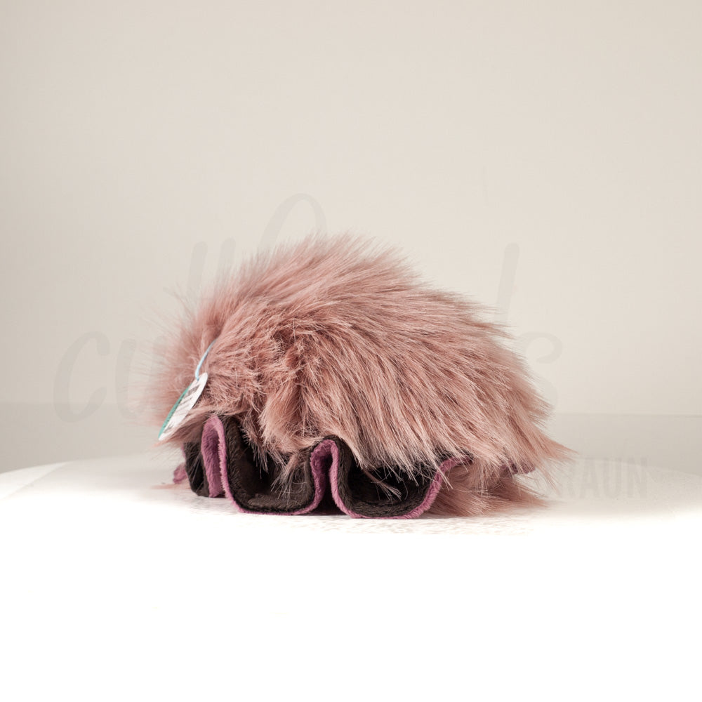 Slightly angled back view of a cuttlepod plush toy, highlighting two-tone ruffled fins, and a cuddly, furry body that comes to a soft point at the rear.