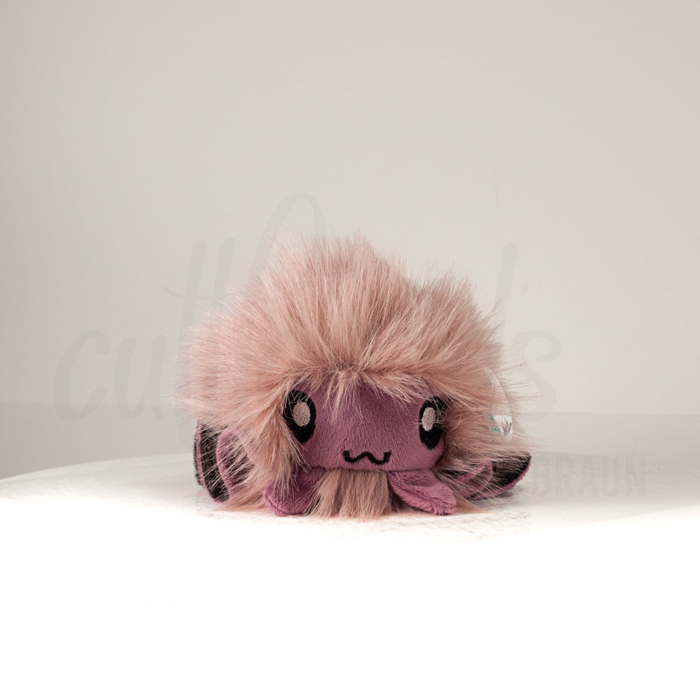 Front view of a cuttlepod plush toy, showcasing its unique form with large, cartoonish eyes, ruffled fins, and a cuddly, furry texture.