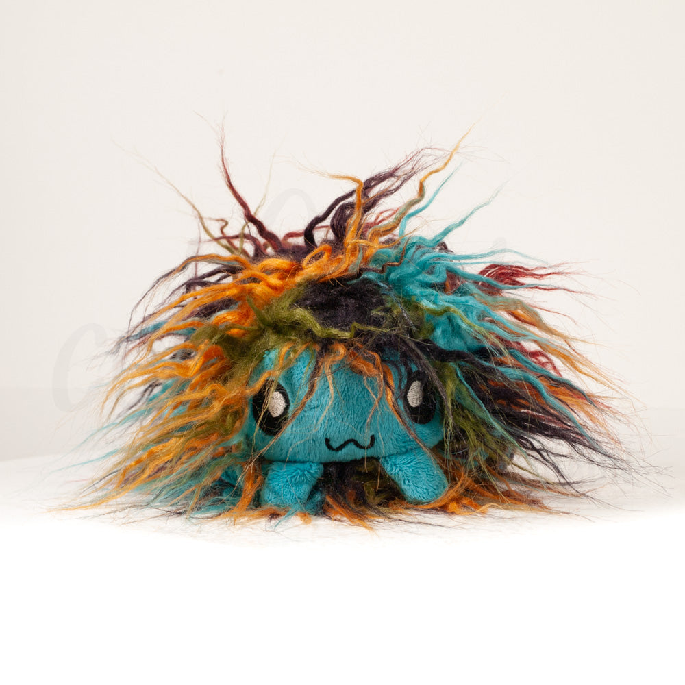 Front view of a cuttlepod plush toy, showcasing its unique form with large, cartoonish eyes, ruffled fins, and a cuddly, furry texture.