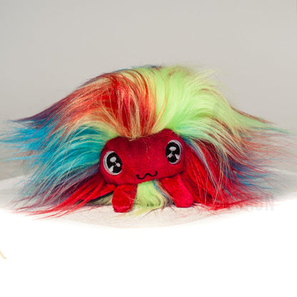 Front view of a cuttlepod plush toy, showcasing its unique form with large, cartoonish eyes, ruffled fins, and a cuddly, furry texture.