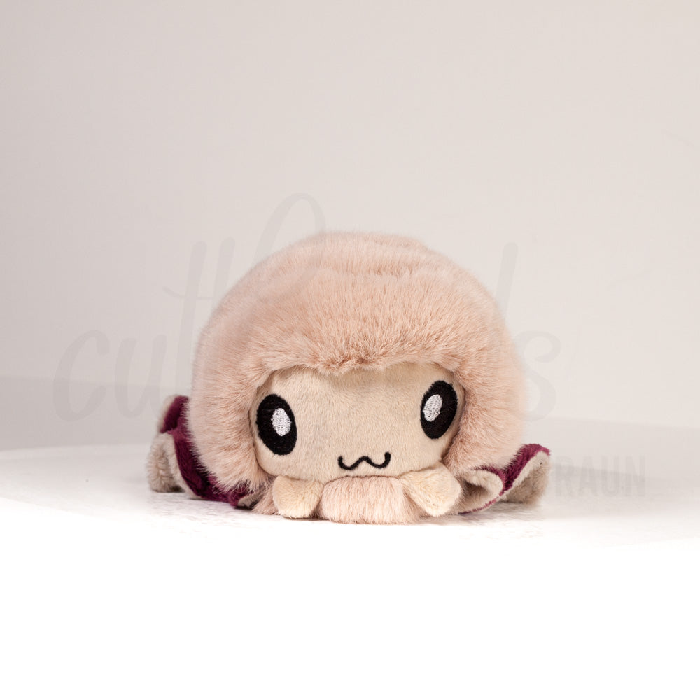 Front view of a cuttlepod plush toy, showcasing its unique form with large, cartoonish eyes, ruffled fins, and a cuddly, furry texture.