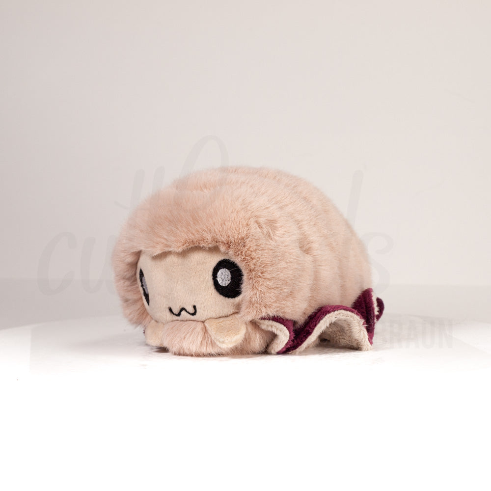 Front view of a cuttlepod plush toy, captured at a slight angle to highlight its charming features: large, cartoonish eyes, ruffled fins, and a cuddly, furry texture.