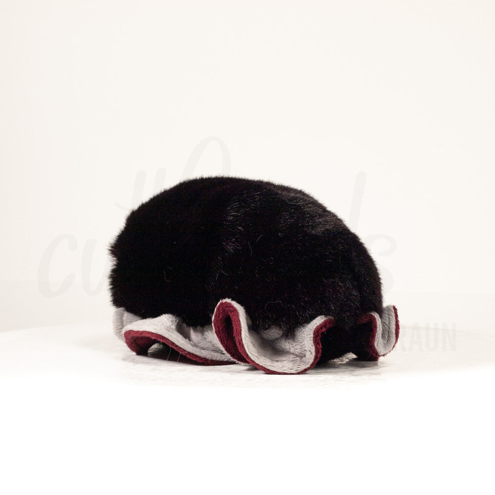 Slightly angled back view of a cuttlepod plush toy, highlighting two-tone ruffled fins, and a cuddly, furry body that comes to a soft point at the rear.