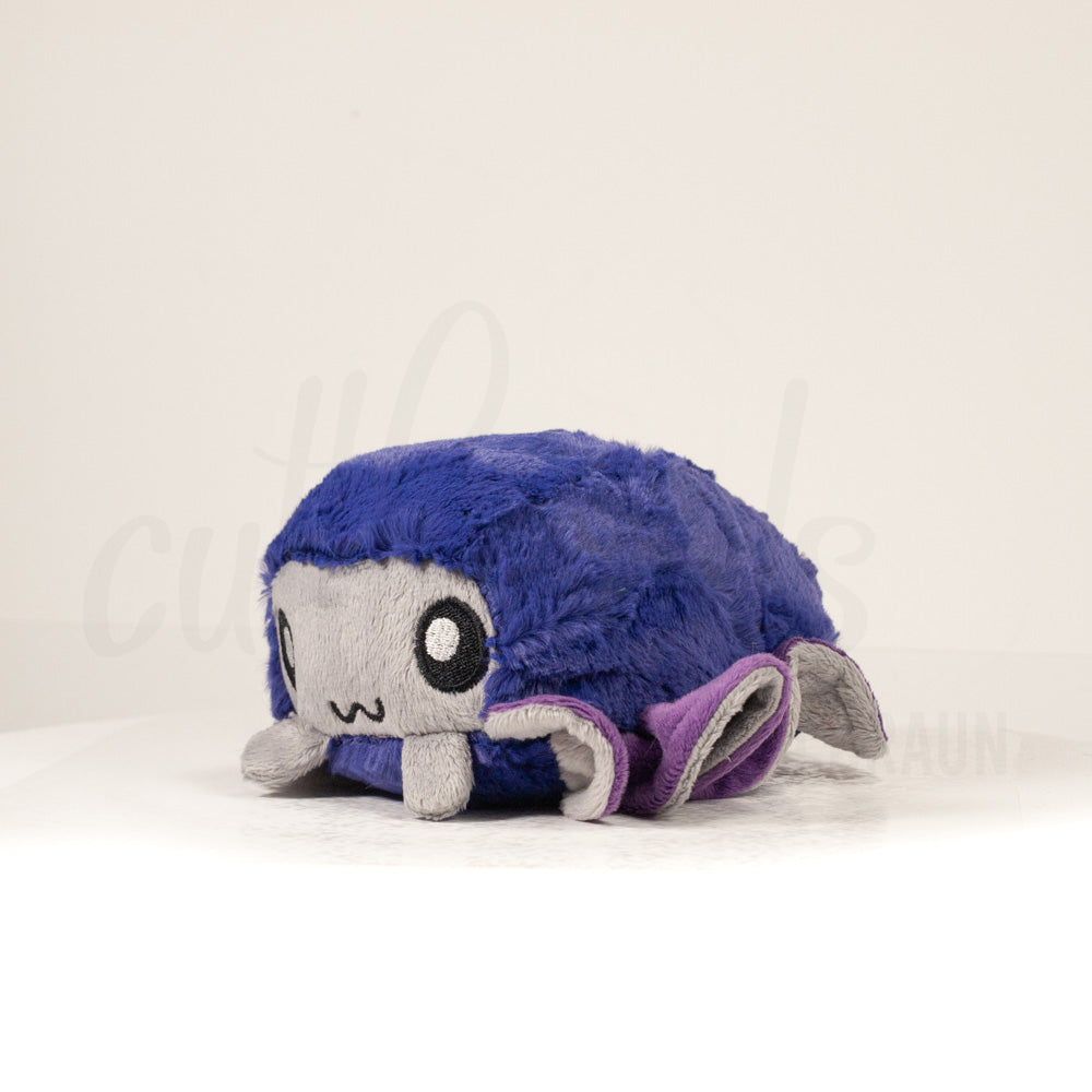 Front view of a cuttlepod plush toy, captured at a slight angle to highlight its charming features: large, cartoonish eyes, ruffled fins, and a cuddly, furry texture.