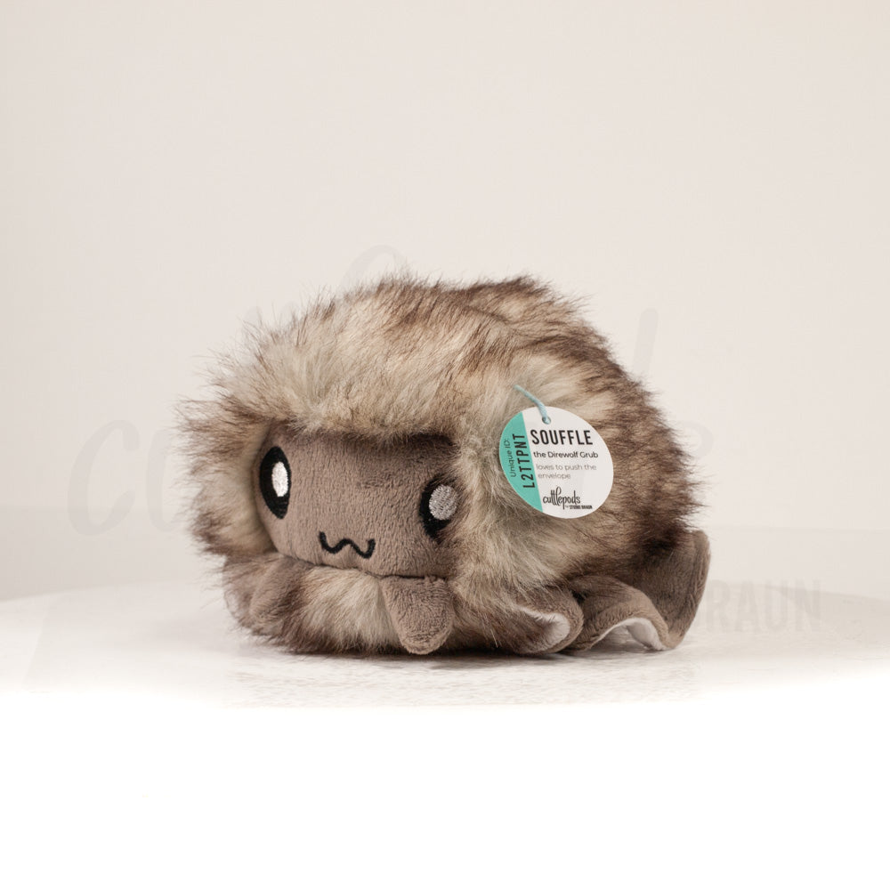 Front view of a cuttlepod plush toy, captured at a slight angle to highlight its charming features: large, cartoonish eyes, ruffled fins, and a cuddly, furry texture.