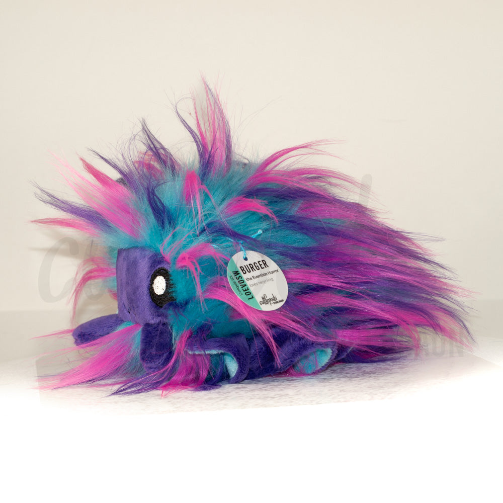 Side profile view of a cuttlepod plush toy, showcasing two-tone ruffled fins, and a cuddly, furry body.