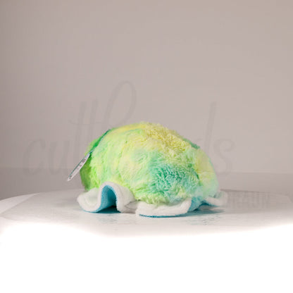 Slightly angled back view of a cuttlepod plush toy, highlighting two-tone ruffled fins, and a cuddly, furry body that comes to a soft point at the rear.