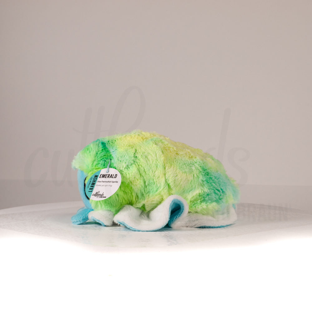 Side profile view of a cuttlepod plush toy, showcasing two-tone ruffled fins, and a cuddly, furry body.