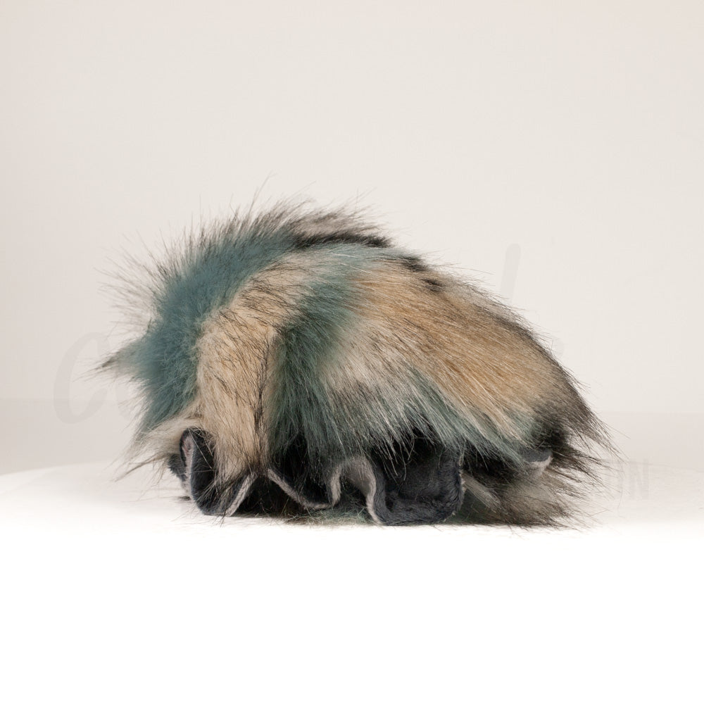 Slightly angled back view of a cuttlepod plush toy, highlighting two-tone ruffled fins, and a cuddly, furry body that comes to a soft point at the rear.