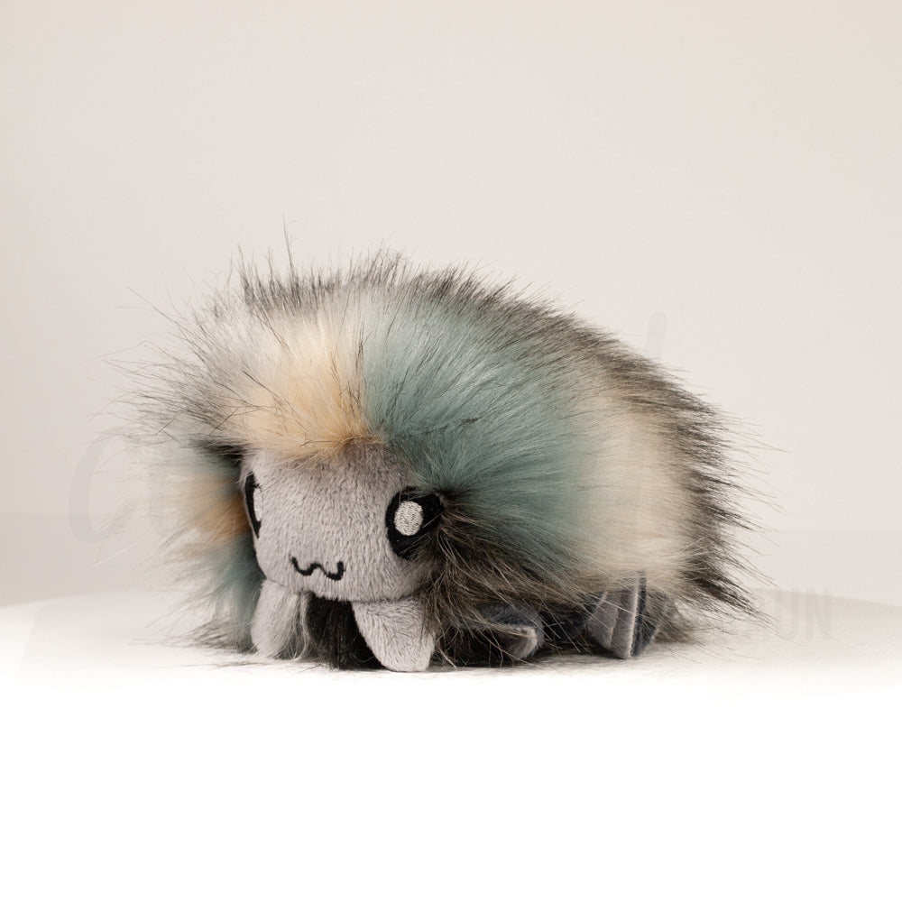 Front view of a cuttlepod plush toy, captured at a slight angle to highlight its charming features: large, cartoonish eyes, ruffled fins, and a cuddly, furry texture.