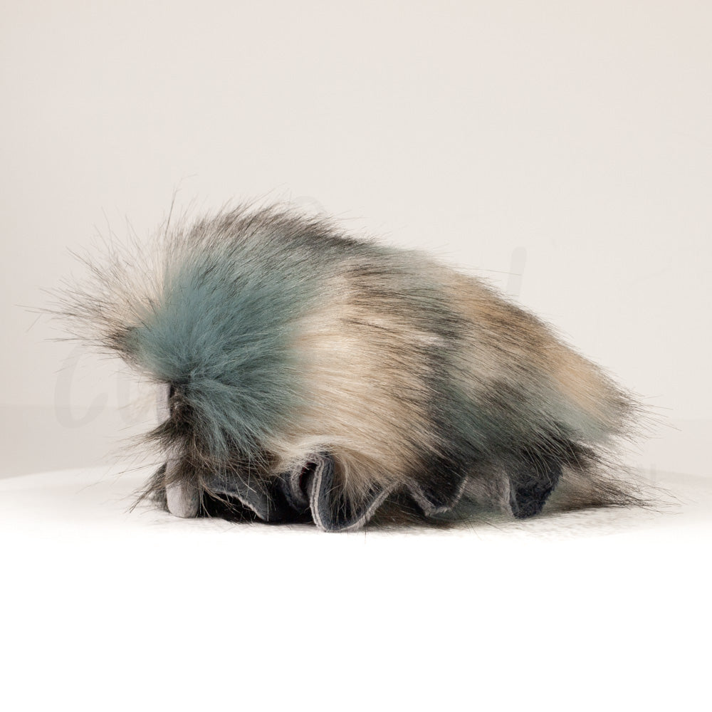 Side profile view of a cuttlepod plush toy, showcasing two-tone ruffled fins, and a cuddly, furry body.