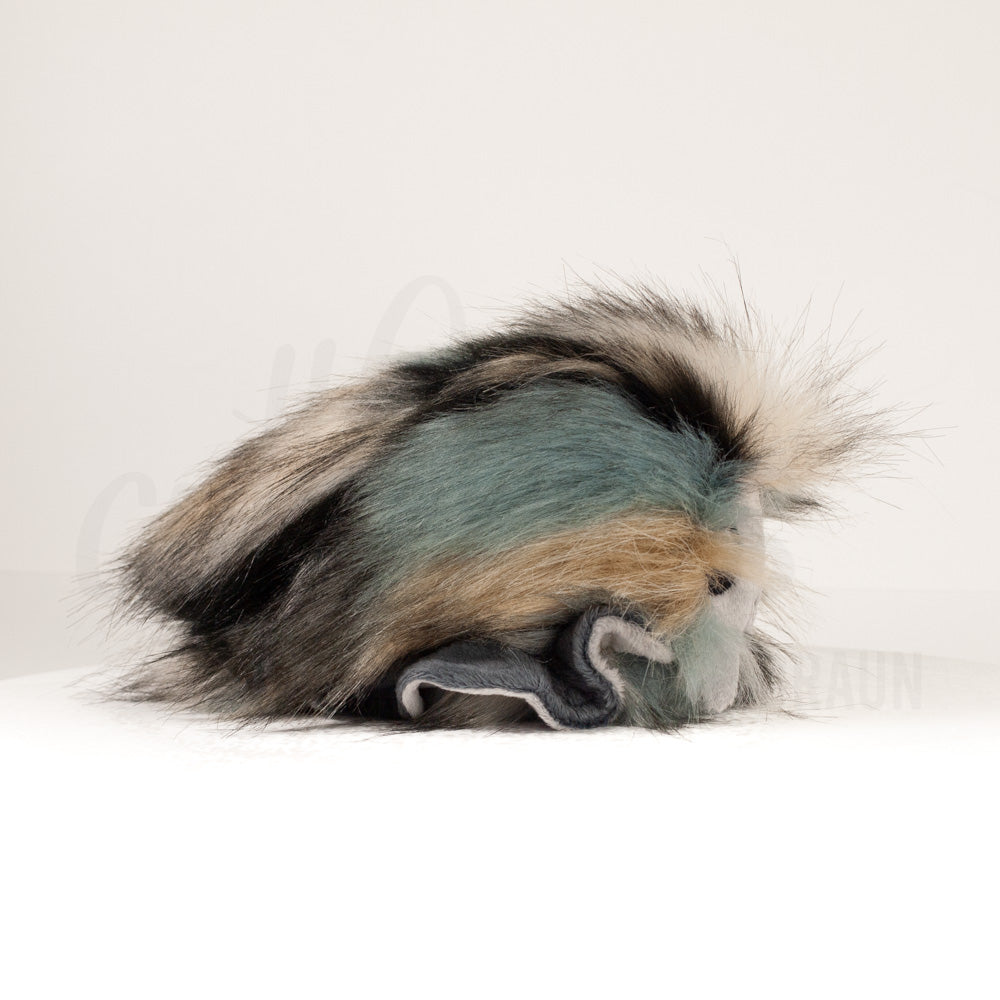 Side profile view of a cuttlepod plush toy, showcasing two-tone ruffled fins, and a cuddly, furry body.