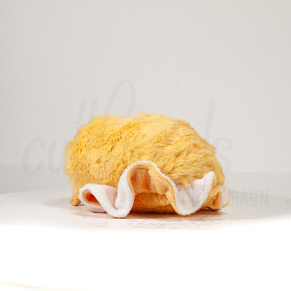 Slightly angled back view of a cuttlepod plush toy, highlighting two-tone ruffled fins, and a cuddly, furry body that comes to a soft point at the rear.