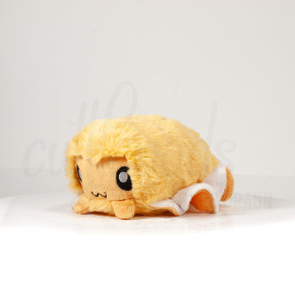 Front view of a cuttlepod plush toy, captured at a slight angle to highlight its charming features: large, cartoonish eyes, ruffled fins, and a cuddly, furry texture.