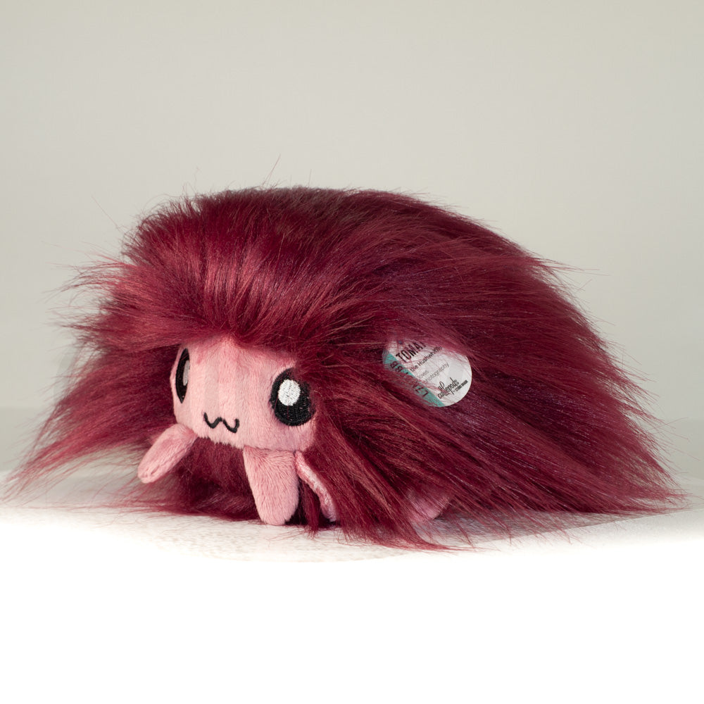 Front view of a cuttlepod plush toy, captured at a slight angle to highlight its charming features: large, cartoonish eyes, ruffled fins, and a cuddly, furry texture.