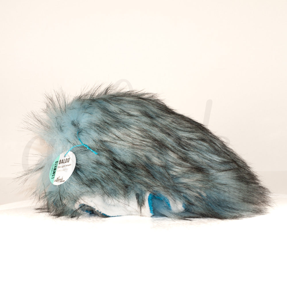 Slightly angled back view of a cuttlepod plush toy, highlighting two-tone ruffled fins, and a cuddly, furry body that comes to a soft point at the rear.