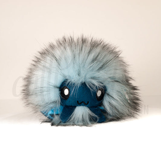 Front view of a cuttlepod plush toy, showcasing its unique form with large, cartoonish eyes, ruffled fins, and a cuddly, furry texture.