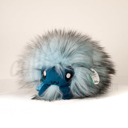 Front view of a cuttlepod plush toy, captured at a slight angle to highlight its charming features: large, cartoonish eyes, ruffled fins, and a cuddly, furry texture.