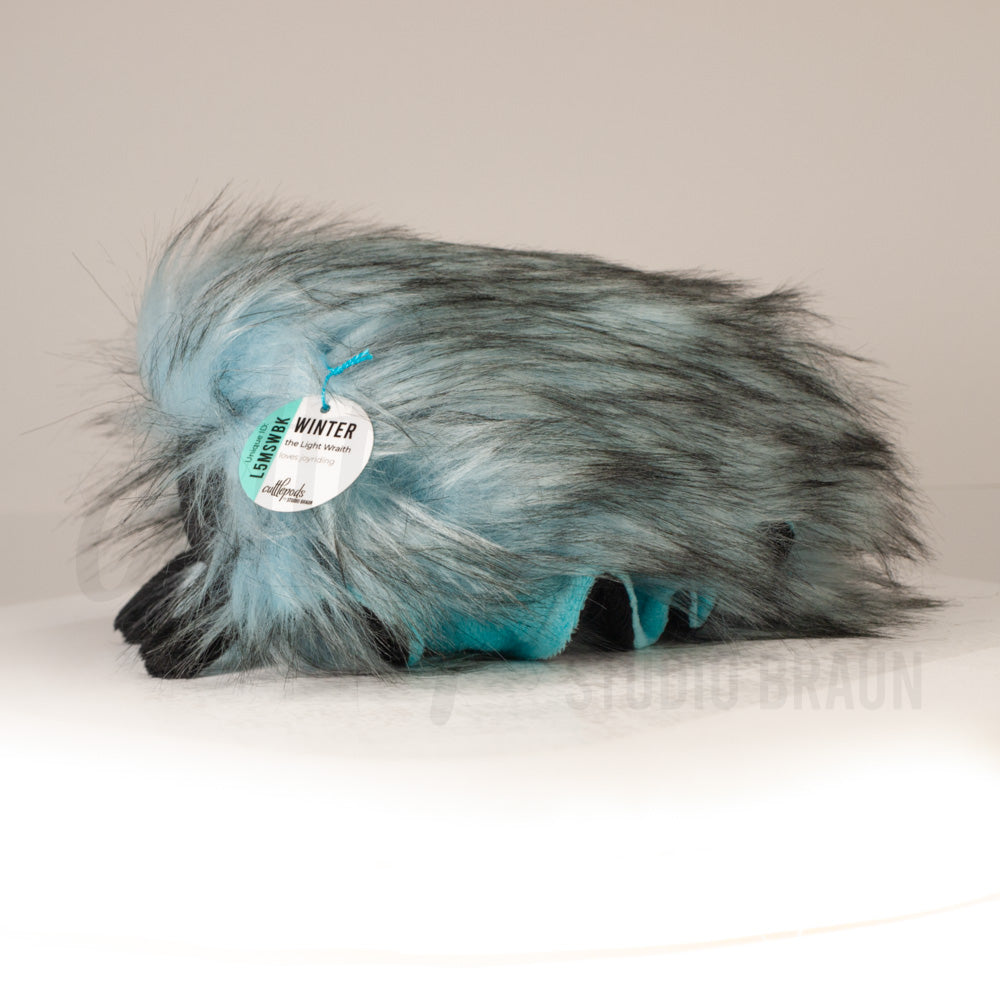 Side profile view of a cuttlepod plush toy, showcasing two-tone ruffled fins, and a cuddly, furry body.