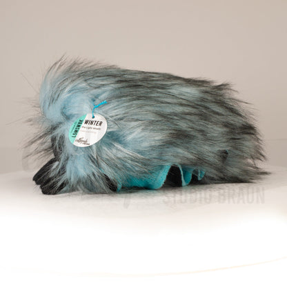 Side profile view of a cuttlepod plush toy, showcasing two-tone ruffled fins, and a cuddly, furry body.