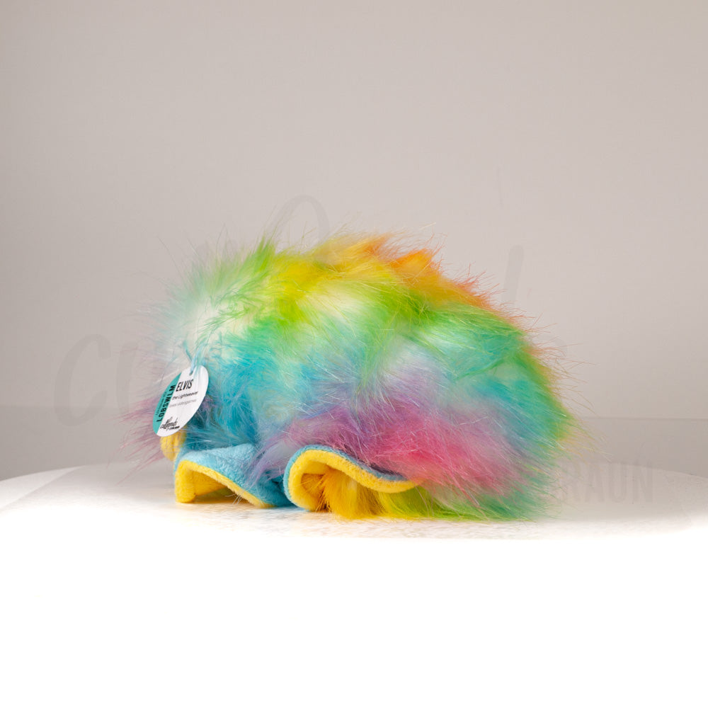 Slightly angled back view of a cuttlepod plush toy, highlighting two-tone ruffled fins, and a cuddly, furry body that comes to a soft point at the rear.