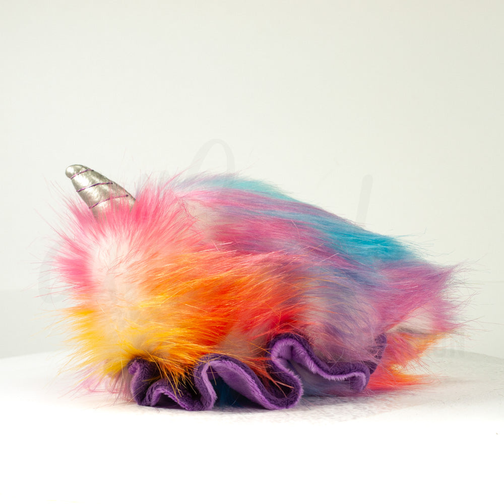 Side profile view of a cuttlepod plush toy, showcasing two-tone ruffled fins, and a cuddly, furry body.