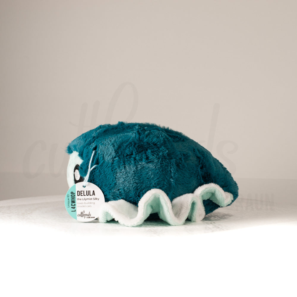 Side profile view of a cuttlepod plush toy, showcasing two-tone ruffled fins, and a cuddly, furry body.