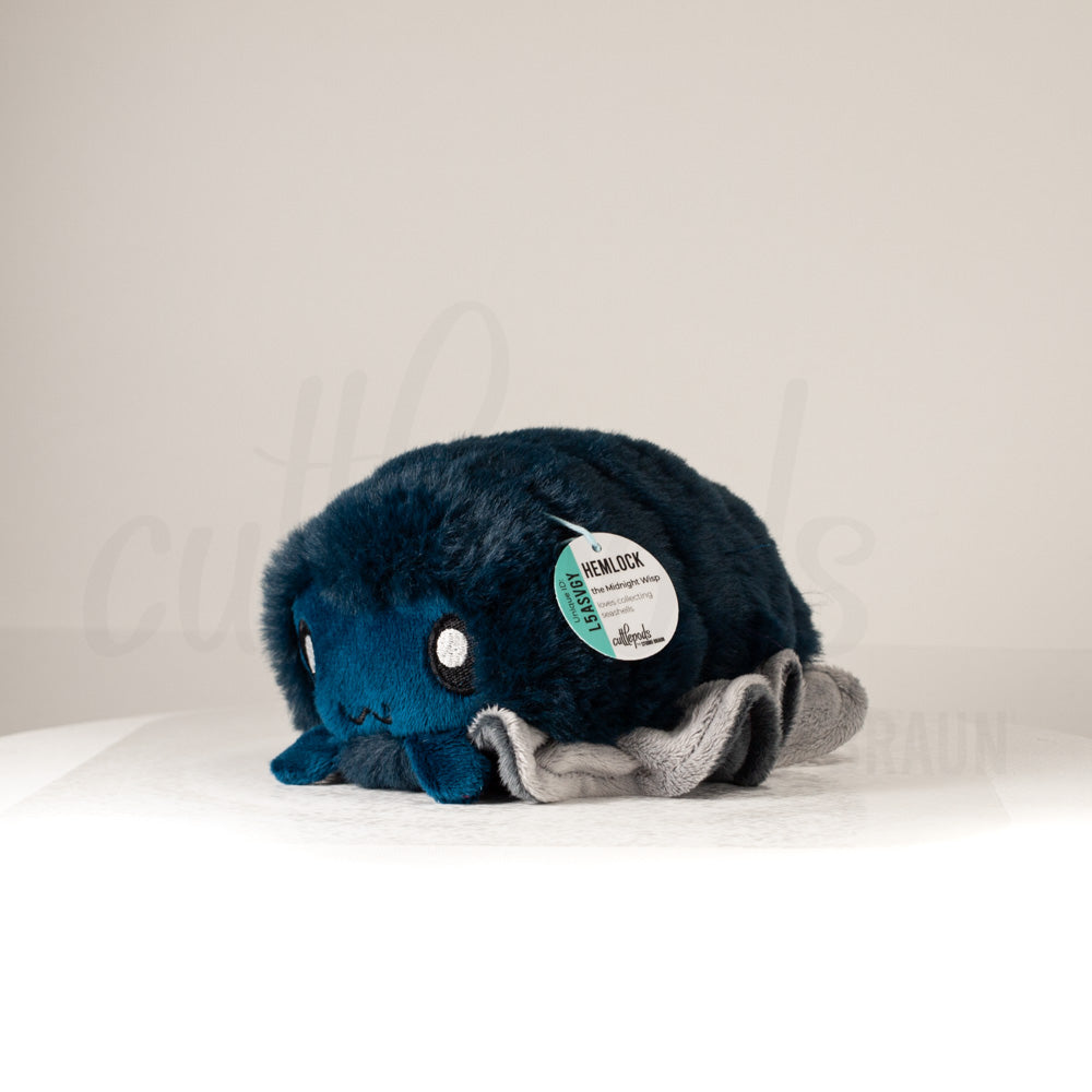 Front view of a cuttlepod plush toy, captured at a slight angle to highlight its charming features: large, cartoonish eyes, ruffled fins, and a cuddly, furry texture.