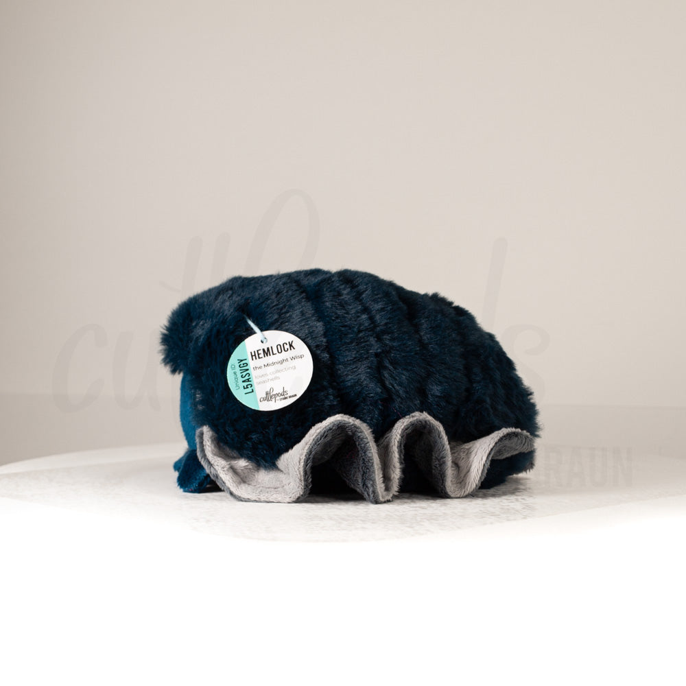 Side profile view of a cuttlepod plush toy, showcasing two-tone ruffled fins, and a cuddly, furry body.