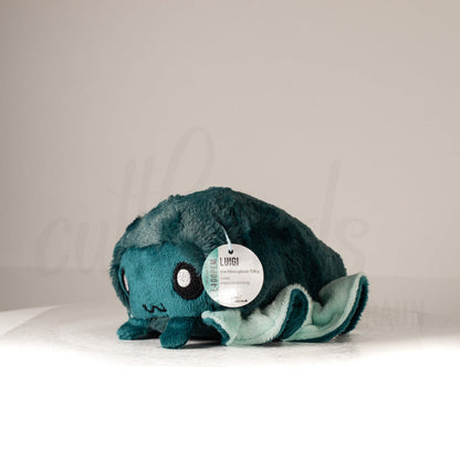 Front view of a cuttlepod plush toy, captured at a slight angle to highlight its charming features: large, cartoonish eyes, ruffled fins, and a cuddly, furry texture.