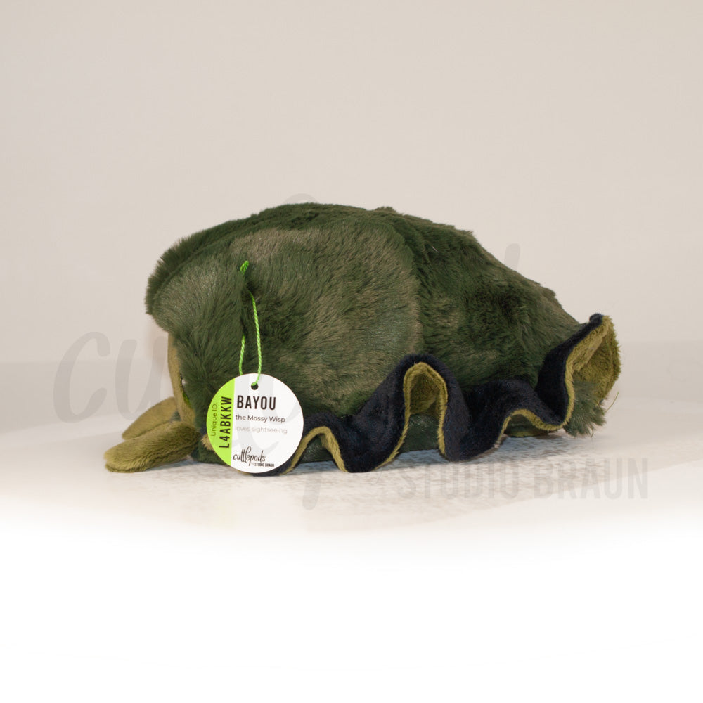 Side profile view of a cuttlepod plush toy, showcasing two-tone ruffled fins, and a cuddly, furry body.