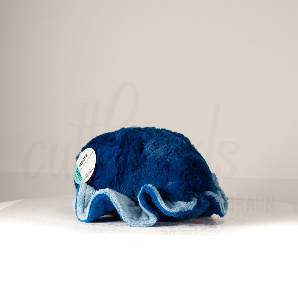 Slightly angled back view of a cuttlepod plush toy, highlighting two-tone ruffled fins, and a cuddly, furry body that comes to a soft point at the rear.