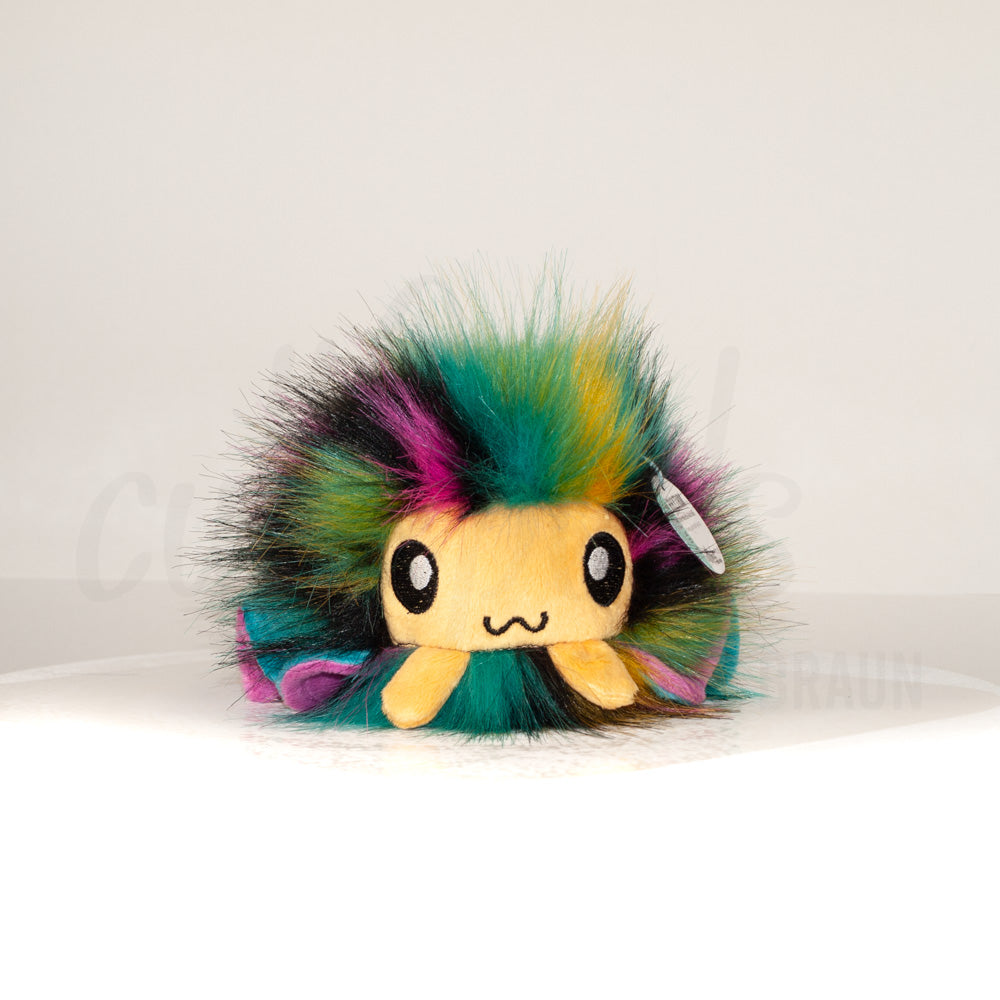 Front view of a cuttlepod plush toy, showcasing its unique form with large, cartoonish eyes, ruffled fins, and a cuddly, furry texture.