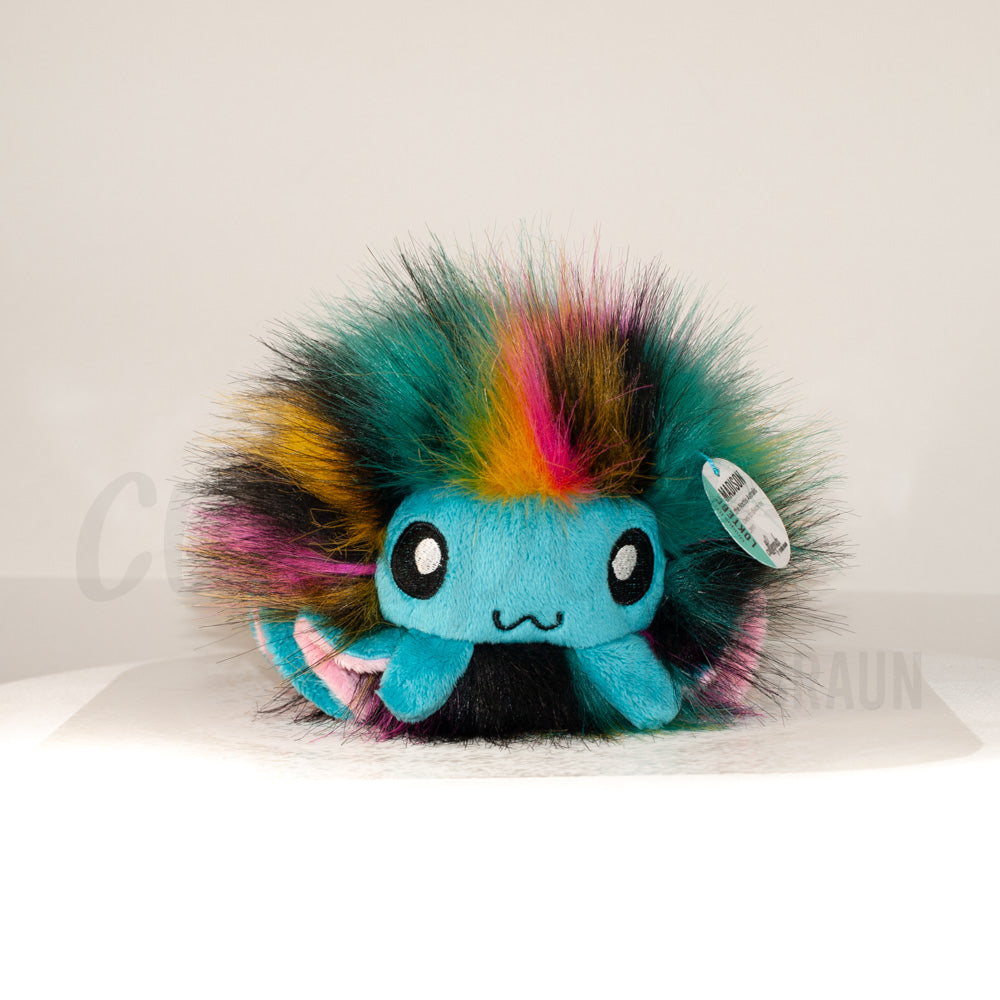 Front view of a cuttlepod plush toy, captured at a slight angle to highlight its charming features: large, cartoonish eyes, ruffled fins, and a cuddly, furry texture.