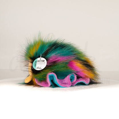 Side profile view of a cuttlepod plush toy, showcasing two-tone ruffled fins, and a cuddly, furry body.