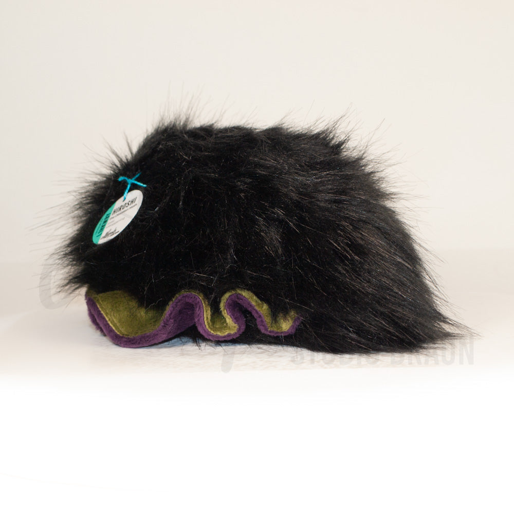 Slightly angled back view of a cuttlepod plush toy, highlighting two-tone ruffled fins, and a cuddly, furry body that comes to a soft point at the rear.