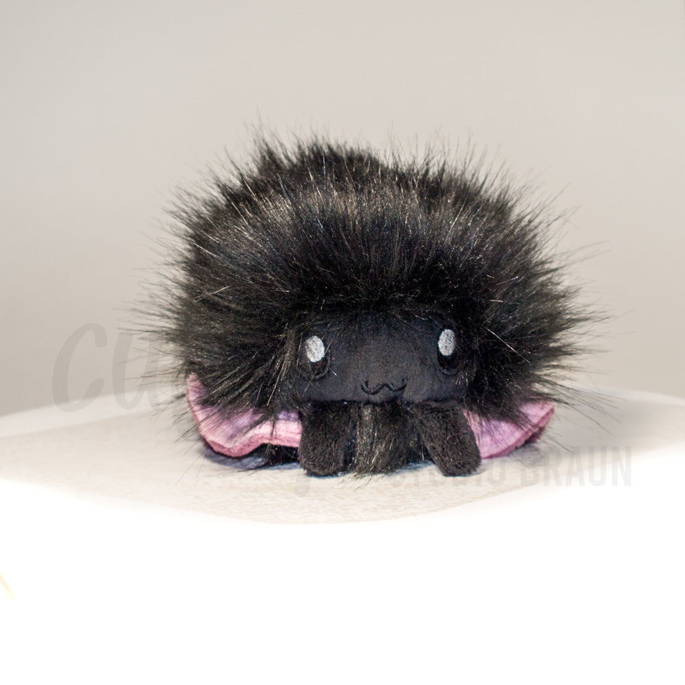 Front view of a cuttlepod plush toy, showcasing its unique form with large, cartoonish eyes, ruffled fins, and a cuddly, furry texture.